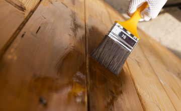 Varnishind natural wood with paint brush Painted wooden surface. Varnishind natural wood with paint brush